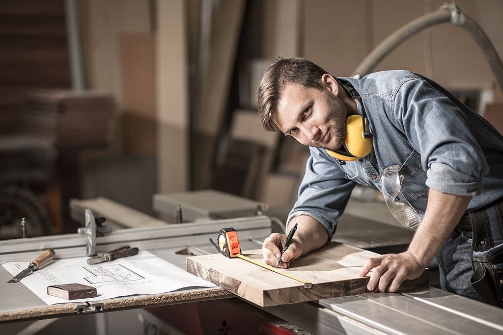Handwerker bei der Arbeit mit Tablet für Zeiterfassung